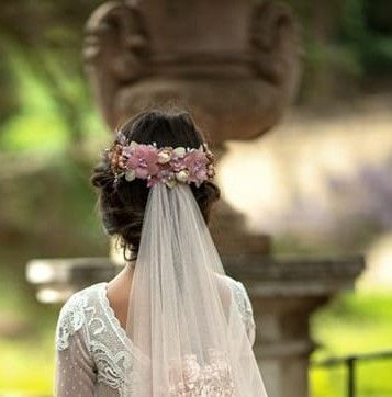 Elegante corona de Comunión en delicados tonos rosas con pistilos en gris, perteneciente a la exclusiva colección La Infantita.