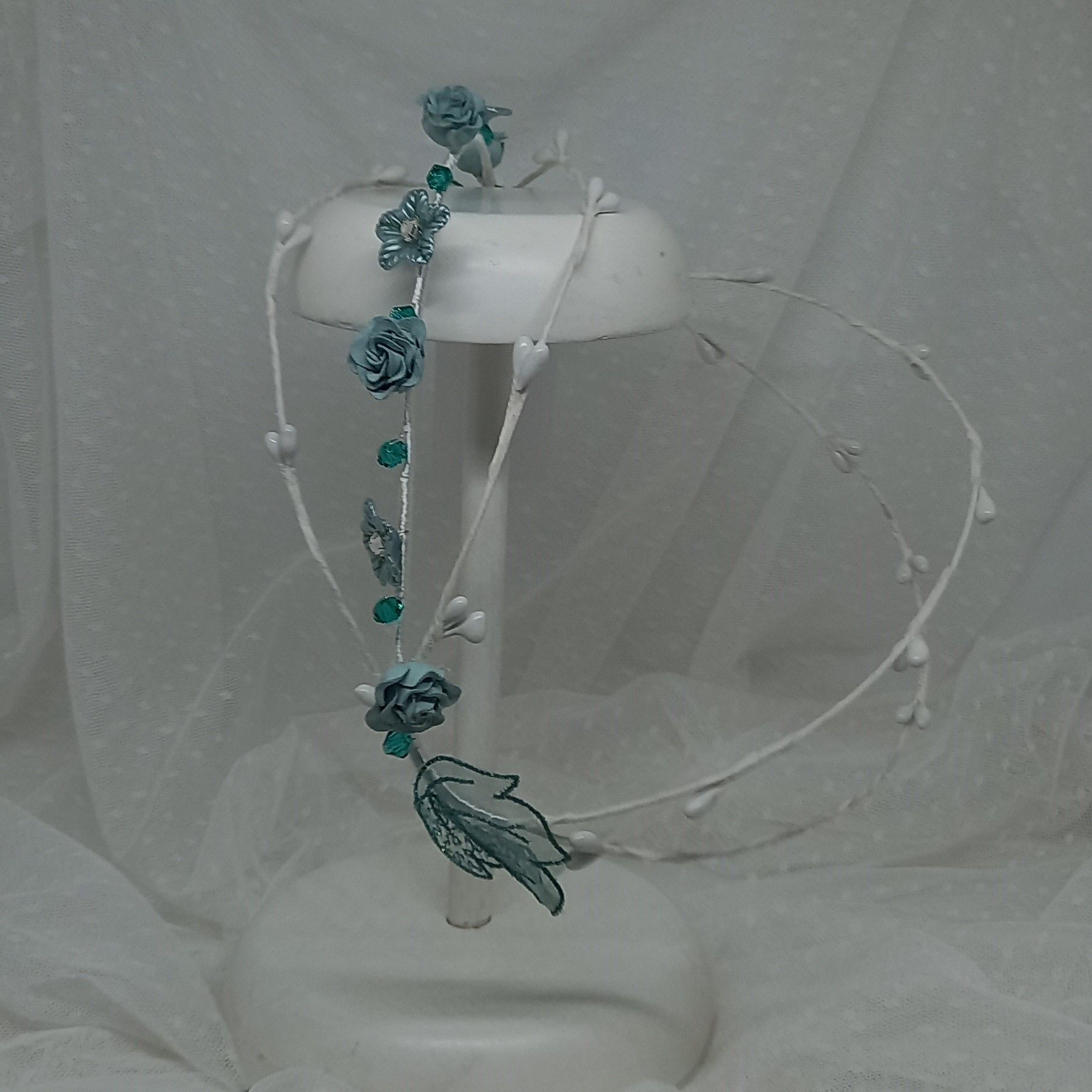 Preciosa corona de comunión de la firma Floritur, elaborada con flores en tonos blancos y verdes.