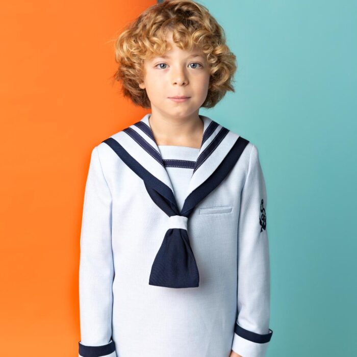 Traje de Comunión marinero Nova Drima 2027 en tonos azules, con pasamanería en la baberola y pantalón azul marino.