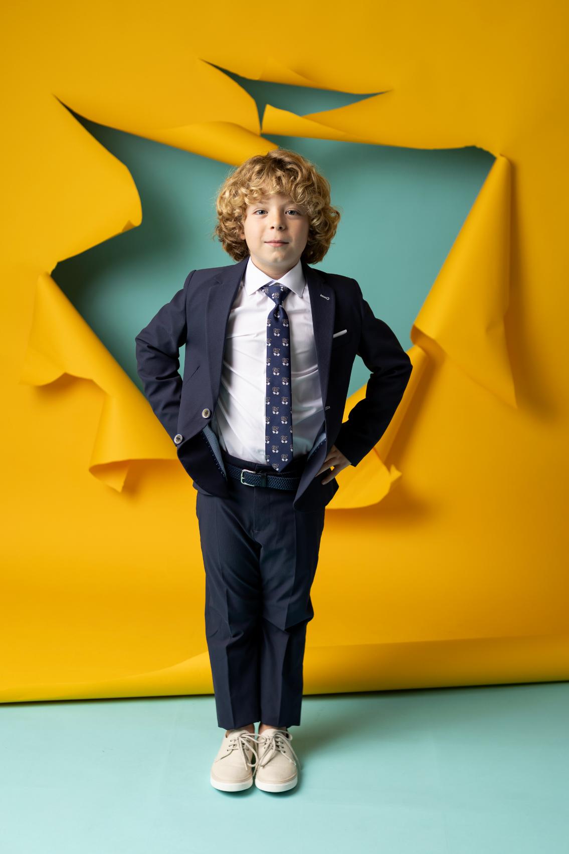 Traje de Comunión de calle marino Nova Drima para niño, compuesto por chaqueta americana, camisa, pantalón y corbata.