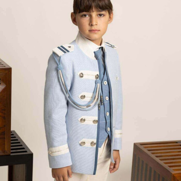 Traje de Comunión almirante Amalio Rubio con chaqueta celeste, pasamanería beige y azul, camisa de cuello camisero, corbata a juego y pantalón beige.