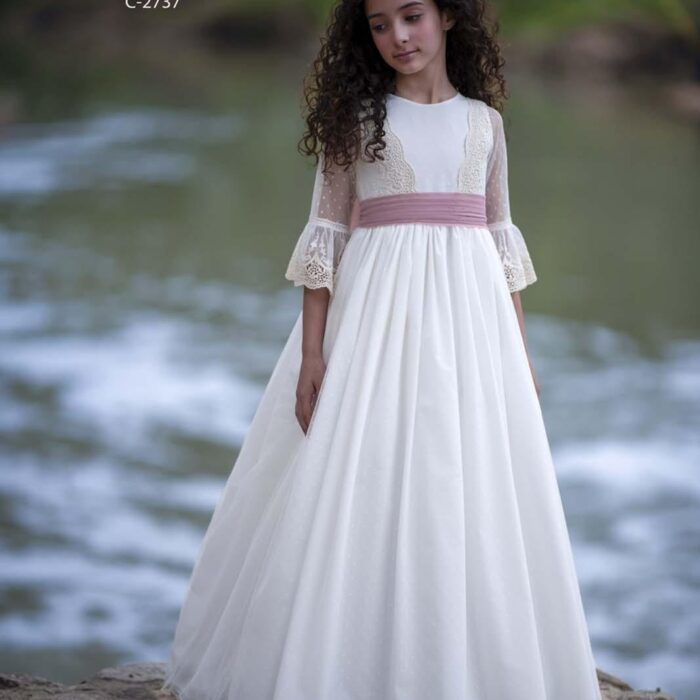 Vestido de comunión Pathi Colección con falda de tul, cuerpo de encaje y lazada rosa nude.